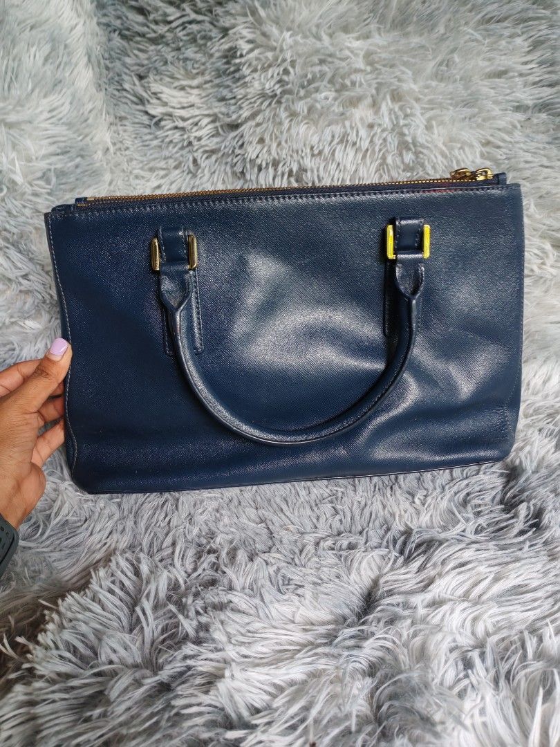 Tory Burch Navy Leather Tote Bag (Category: Luxury Bags & Wallets) located in Manila. Submitted by camellesal67218 (Listing ID 1452186898, Image 2). Description: - Genuine navy blue leather Tory Burch tote bag - Elegant gold hardware details - Secure zip closure - Multiple interior compartments for organization - Spacious enough for daily essentials - Perfect for work or casual outings - A timeless addition to your collection.
