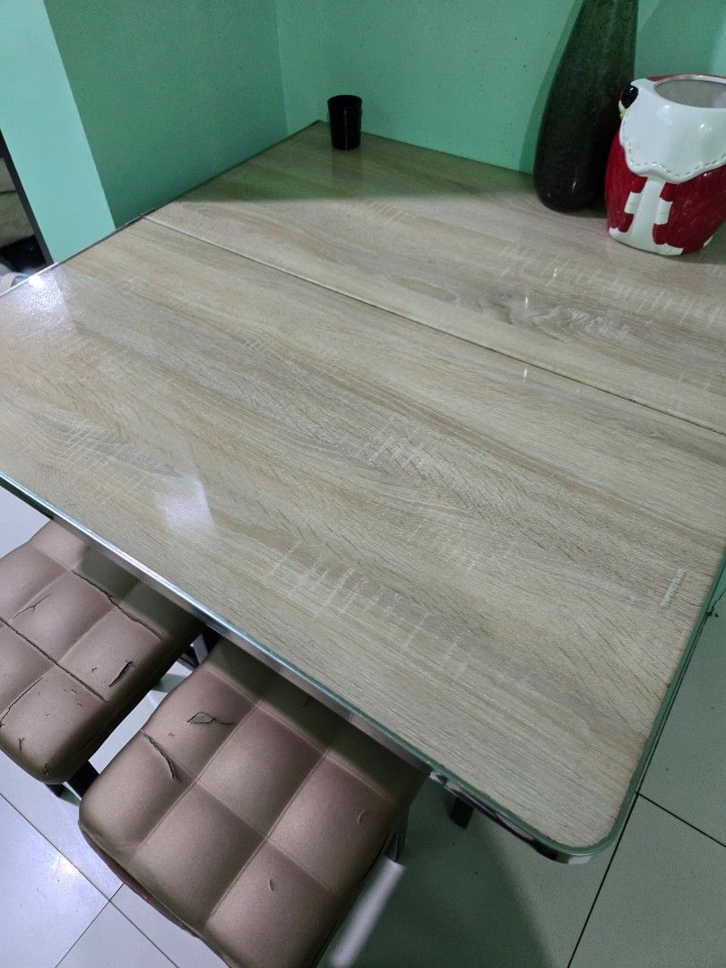 Wooden Dining Table with 2 Chairs (Category: Tables & Sets) located in Manila. Submitted by mstibayan (Listing ID 1452179546, Image 3). Description: - Light wood grain finish dining table - Smooth tabletop surface - Includes two chairs with tufted, padded seats - Chairs show some signs of wear (peeling upholstery) - Ideal for small dining areas or kitchen nooks - Comfortable seating.