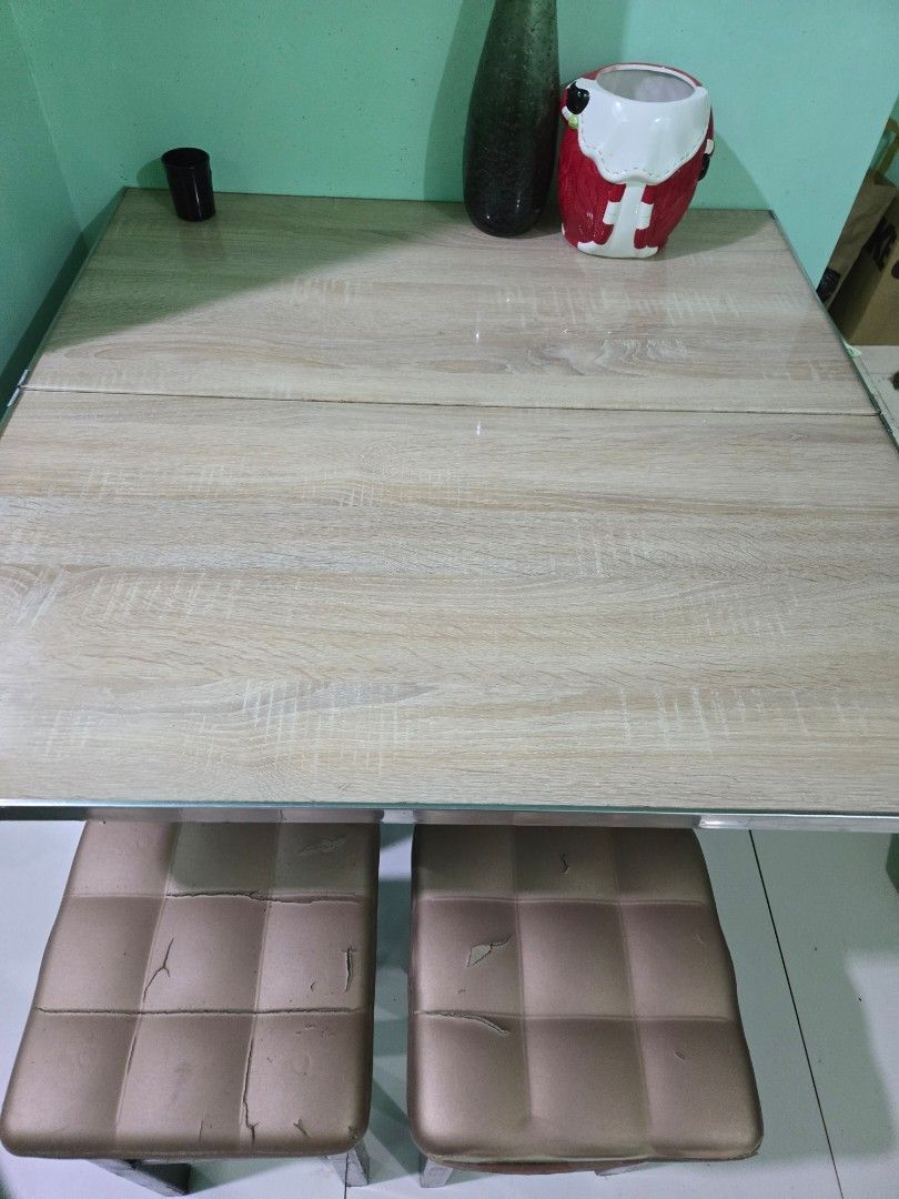 Wooden Dining Table with 2 Chairs (Category: Tables & Sets) located in Manila. Submitted by mstibayan (Listing ID 1452179546, Image 2). Description: - Light wood grain finish dining table - Smooth tabletop surface - Includes two chairs with tufted, padded seats - Chairs show some signs of wear (peeling upholstery) - Ideal for small dining areas or kitchen nooks - Comfortable seating.