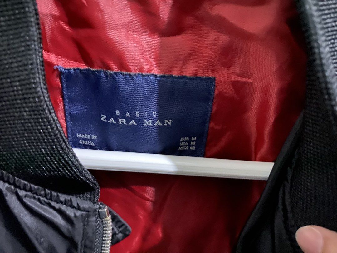Zara Man Black Bomber Jacket with Patches (Category: Coats, Jackets and Outerwear) located in Makati City. Submitted by dripfitsmanila (Listing ID 1452242055, Image 3). Description: - Zara Man Black Bomber Jacket - Size: Medium (M) - Unique patches on front and sleeve - Contrasting red lining inside - Ideal for casual outfits.