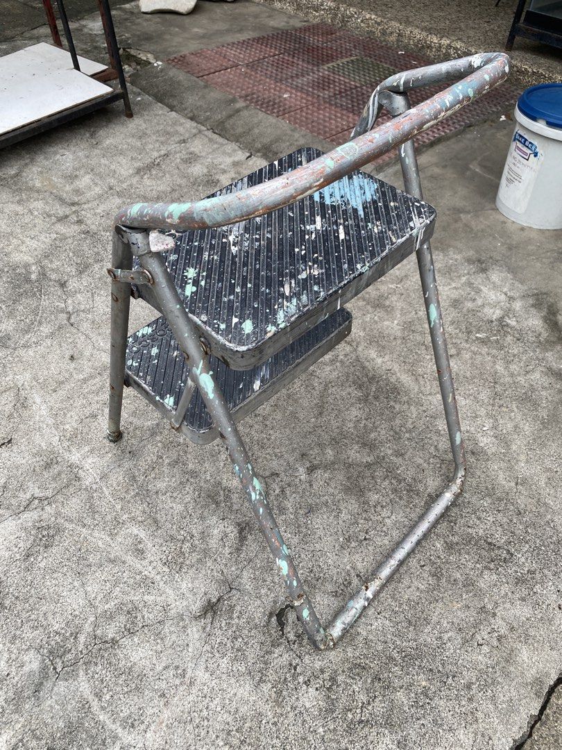 2-Step Metal Step Stool with Handle (Category: Chairs) located in Manila. Submitted by tavorafrancis8096 (Listing ID 1452433201, Image 3). Description: - Sturdy metal construction - Two steps for added height - Convenient handle for extra stability - Shows minor paint splatters from normal use - Folds flat for easy storage - Ideal for reaching high shelves or small DIY tasks.