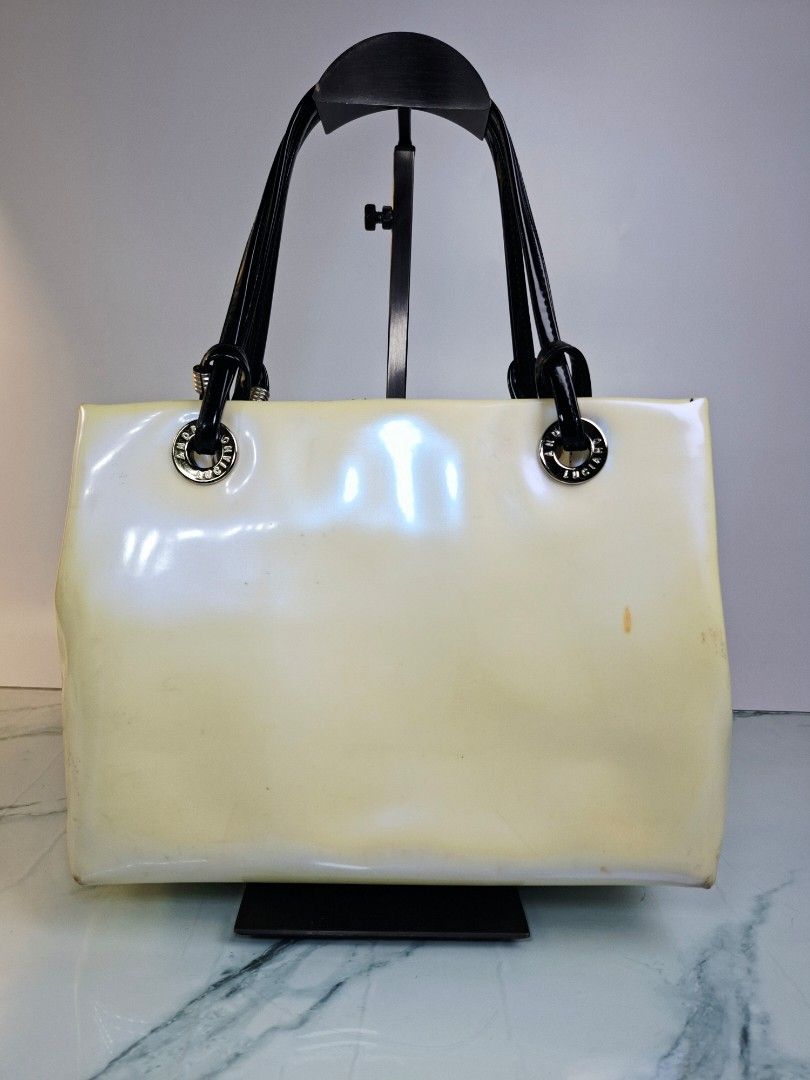 ANDRE LUCIANO Patent Leather Handbag (Category: Tote Bags) located in Pasay City. Submitted by onick_79 (Listing ID 1452349799, Image 2). Description: ​​Chic and stylish cream patent shoulder bag featuring a bold front logo, black patent dual handles, silver hardware, and a fun printed interior lining! ​Brand: Andre Luciano ​Condition: Pre-loved with visible signs of use/color transfer (priced accordingly; please manage expectations and see photo