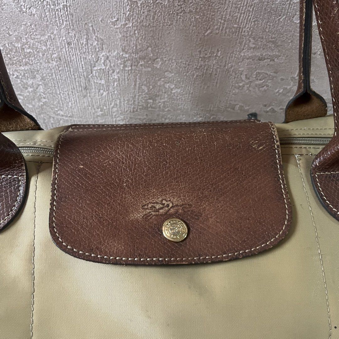 Authentic Longchamp Le Pliage Tote Bag Beige (Category: Luxury Bags & Wallets) located in Davao. Submitted by kanto-10 (Listing ID 1452331101, Image 2). Description: Authentic Large Long Champ Le Pliage (Long Handle) - Classic Longchamp tote bag - Beige nylon with brown leather handles and trim - Zips closed for security - Leather shows some wear and scuffing - Nylon has some marks and stains - Still a great bag for everyday use - Plenty of inter