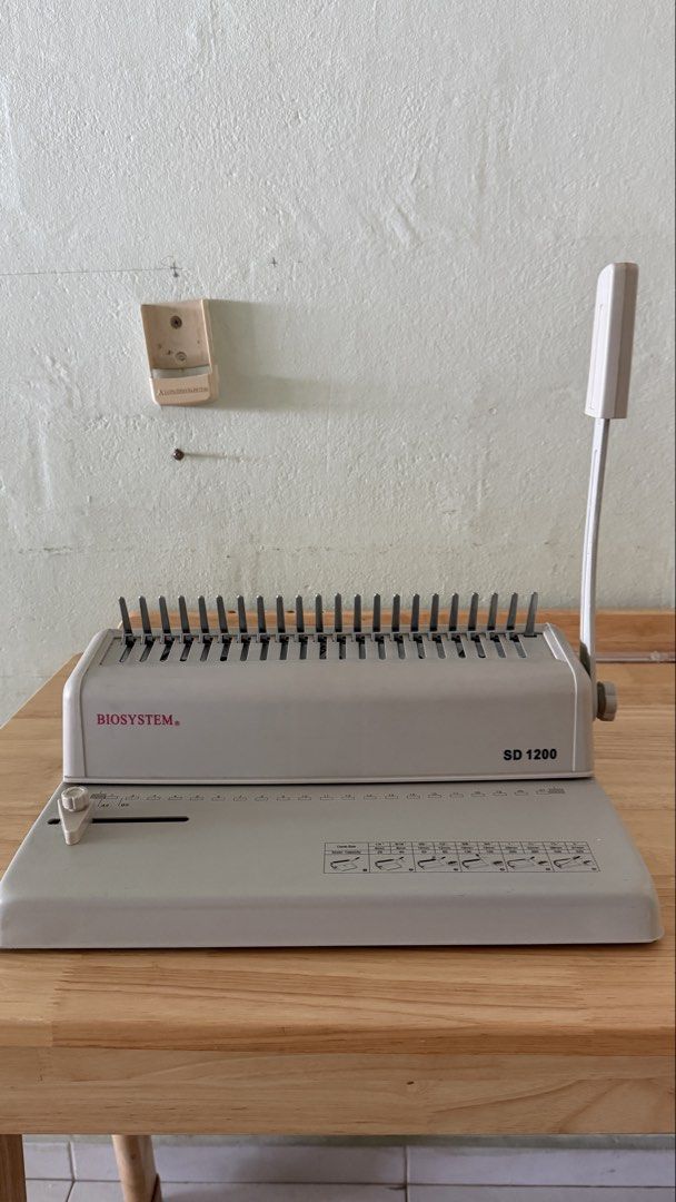 comb Binding Machine, SD 1200 Biosystem (Category: Office & Business Technology) located in Singapore. Submitted by schongcm (Listing ID 1452372028, Image 2). Description: - excellent 10/10 condition Brand: Biosystem SD 1200 binding machine - bind notes and make booklets for training or study - Includes comb binding spines - Ideal for organizing documents or reports - Features an easy-to-use lever for punching and binding.