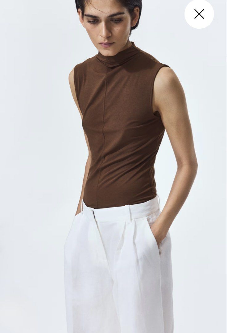Brown Mock Neck Sleeveless Top (Category: Sleeveless) located in Manila. Submitted by paperthread (Listing ID 1452487320, Image 2). Description: - Brown sleeveless top - Mock neck design - Textured fabric for a chic look - Comfortable fit - Perfect for layering or wearing on its own - Versatile: pairs well with trousers or skirts.