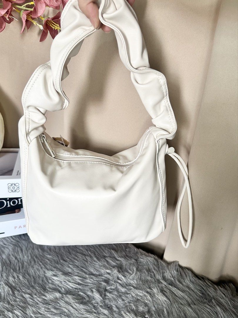 Earth Cream Ruched Handle Shoulder Bag (Category: Shoulder Bags) located in Rizal. Submitted by stuffbuyph (Listing ID 1452350937, Image 2). Description: - Stylish cream shoulder bag - Features a trendy ruched handle - Convenient side drawstring detail - Secure zipper closure - Made from durable faux leather material - Ideal for everyday use - Perfectly fits your daily essentials.