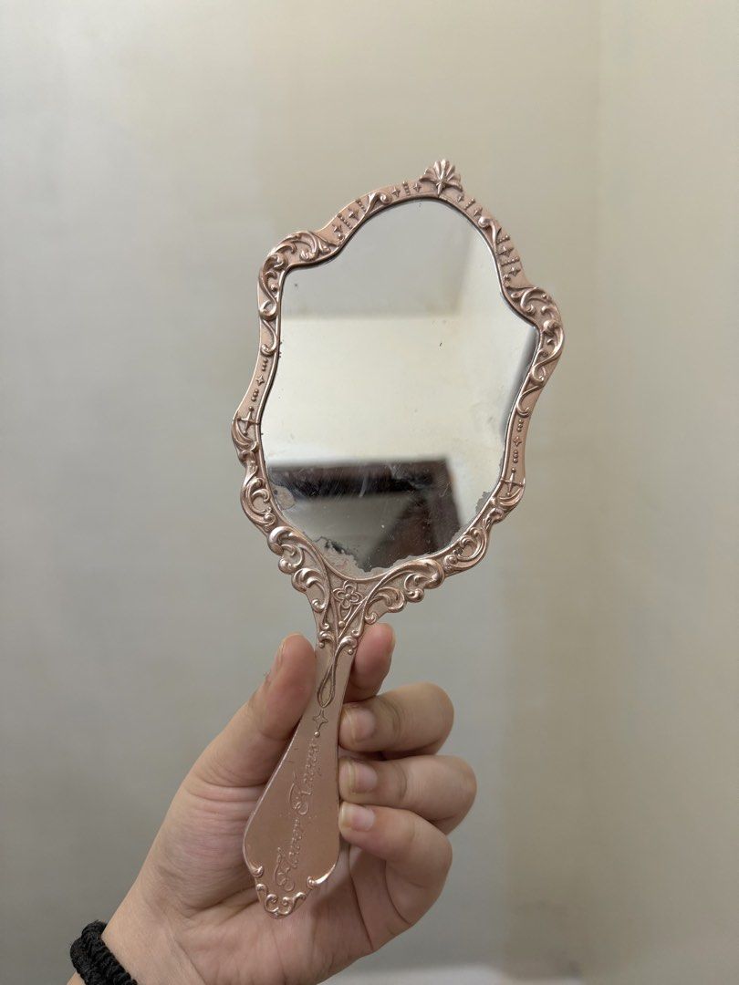 Flower Knows Handheld Mirror - Vintage Cherub Design (Category: Mirrors) located in Cebu City. Submitted by pinkflames05 (Listing ID 1452390397, Image 2). Description: - Vintage-inspired handheld mirror - Ornate cherub and crown design on the back - Lovely filigree pattern on the frame - Clear mirror, perfect for makeup application - Can also be used as a decorative piece - Handle features engraved text - Issue is already there.