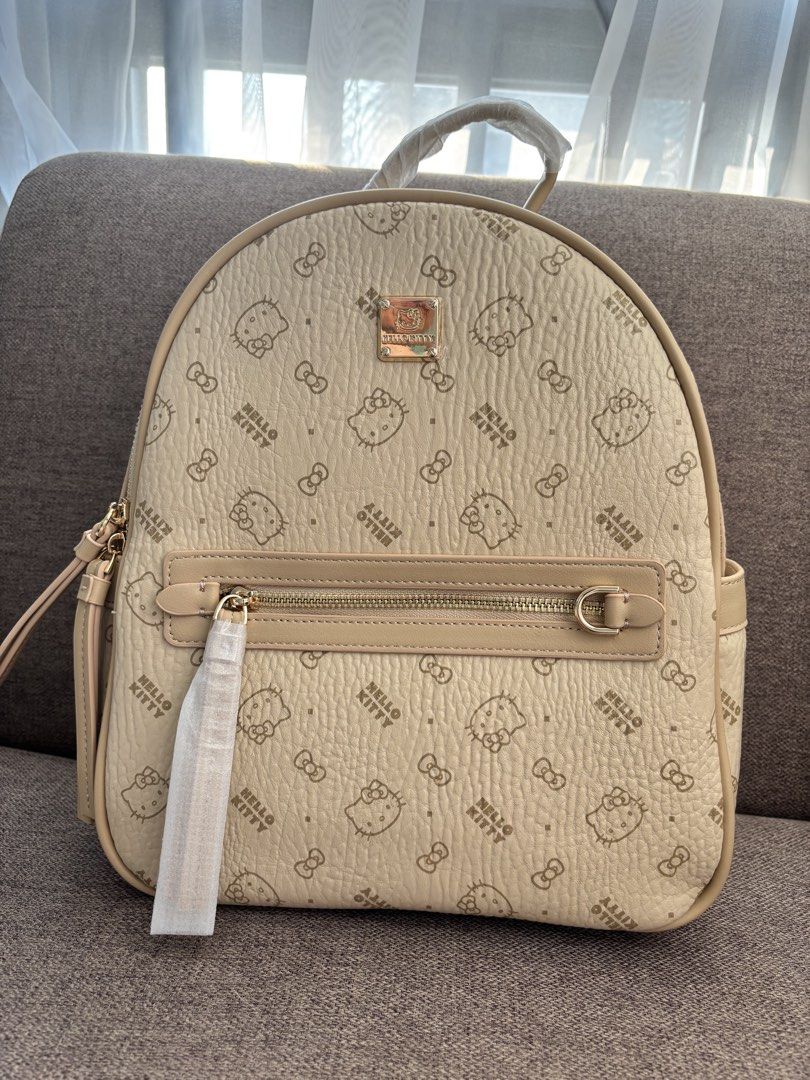 Hello Kitty Beige Monogram Backpack (Category: Backpacks) located in Mexico. Submitted by 3everything (Listing ID 1452421176, Image 1). Description: - Adorable beige backpack featuring an all-over Kitty and bow print. - Convenient front zip pocket for easy access to essentials. - Adjustable straps for a comfortable, customized fit. - Comes with a complimentary Kitty dust bag and box - Ideal for everyday adventures or your next getaway..