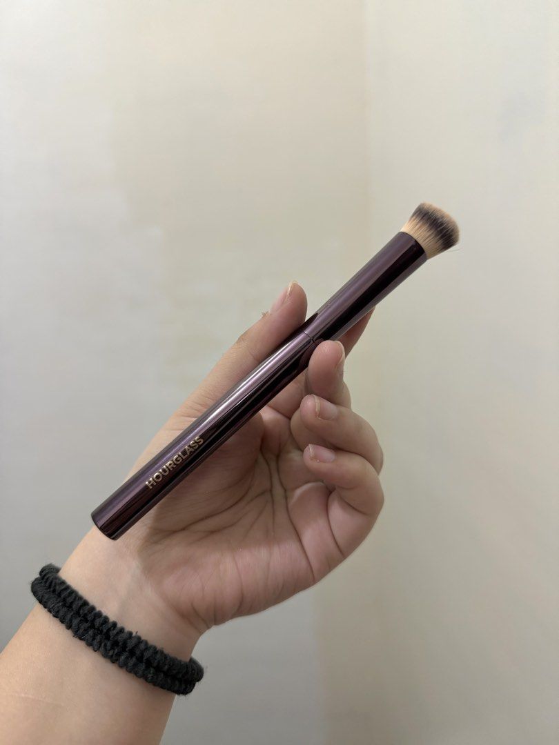 Hourglass Makeup Brush (Category: Makeup) located in Cebu City. Submitted by pinkflames05 (Listing ID 1452390807, Image 1). Description: - Hourglass makeup brush - Deep plum handle with subtle striping - Dense, tapered brush head for foundation or concealer - Small mark on handle (visible in last photo) - Cleaned and sanitized, ready for a new home - Issue: may little crack as u can see sa last photo.