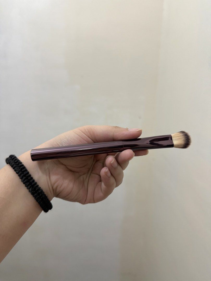 Hourglass Makeup Brush (Category: Makeup) located in Cebu City. Submitted by pinkflames05 (Listing ID 1452390807, Image 3). Description: - Hourglass makeup brush - Deep plum handle with subtle striping - Dense, tapered brush head for foundation or concealer - Small mark on handle (visible in last photo) - Cleaned and sanitized, ready for a new home - Issue: may little crack as u can see sa last photo.