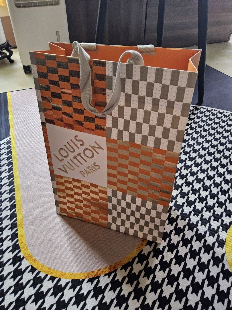 Louis Vuitton Paris Paper Bag (Category: Luxury Bags & Wallets) located in Alaminos. Submitted by shee09 (Listing ID 1452364942, Image 2). Description: - Authentic Louis Vuitton Paris Paper bag - Unique checkered and orange pattern - Grey ribbon handles - Ideal for gifting or storage - Approximate dimensions: 30cm x 25cm x 10cm.