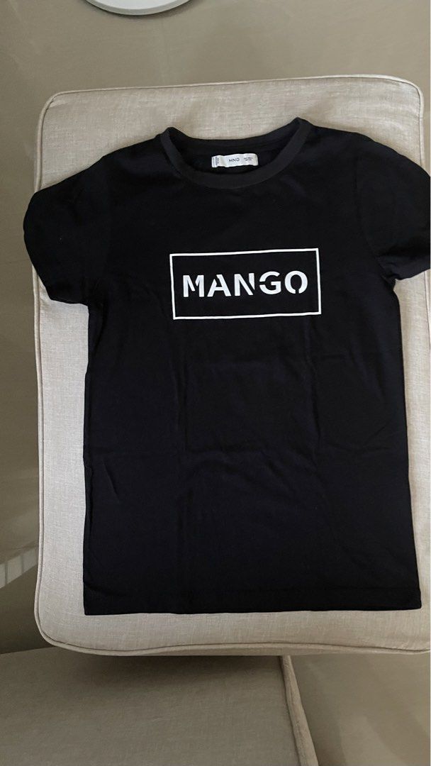 Mango Black T-shirt with White Logo (Category: Shirts) located in Angat. Submitted by eltiff (Listing ID 1452438124, Image 1). Description: - Worn once only - Fits up to bust size 34 - Color: Black - Design: Classic t-shirt with white Mango logo on front - Material: Comfortable cotton - Style: Casual, easy to pair with jeans or shorts.