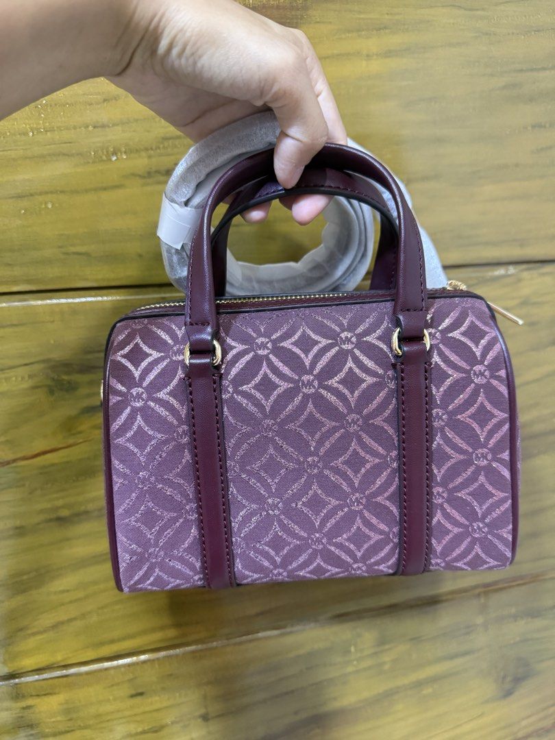Michael Kors Travel Duffle Bag (Category: Luxury Bags & Wallets) located in Iriga City. Submitted by pureloveyaes (Listing ID 1452322608, Image 2). Description: - Brand: Michael Kors - Color: Burgundy with MK logo pattern - Hardware: Gold-tone - Features: Detachable shoulder strap - Condition: Brand new with original tags attached - Perfect for: Weekend trips.