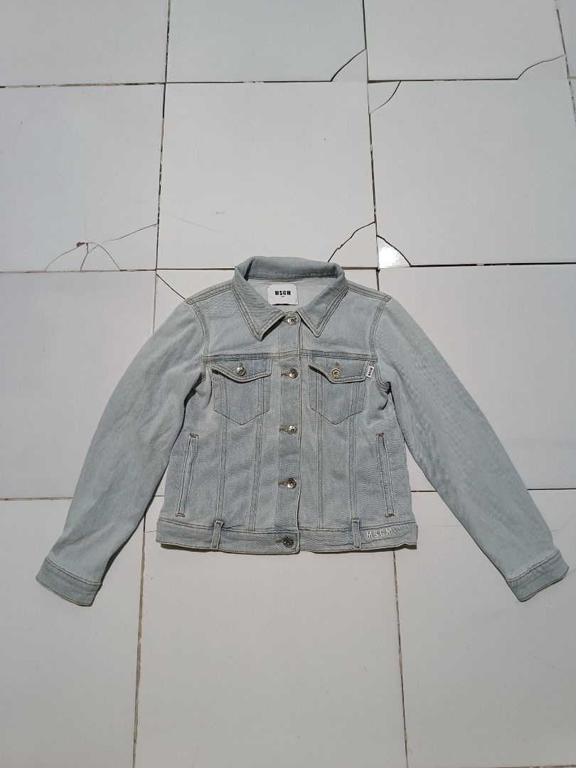 MSG M Kids Light Wash Denim Jacket (Category: Babies & Kids Fashion) located in Barotac Nuevo. Submitted by gray101 (Listing ID 1452445923, Image 1). Description: - MSGM Kids light wash denim jacket - Features iconic MSGM logo printed on the back - Classic button-up front with chest pockets - Made from soft cotton with added stretch for comfort - Size: Tag says Tg. 10 Anni (approximately 10 years old) - Perfect for stylish everyday wear.