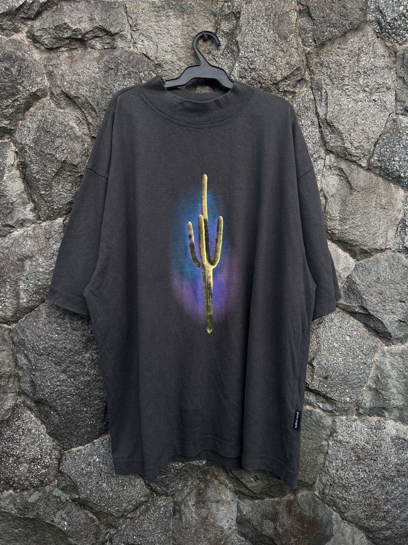 Palm Angels Cactus Graphic T-Shirt (Category: Tshirts & Polo Shirts ) located in Baguio. Submitted by pinkpixie (Listing ID 1452490254, Image 1). Description: Authentic - Dark grey t-shirt - Vibrant cactus graphic with purple & blue aura - Mock neck design - Short sleeves - Palm Angels side tag - Perfect statement piece.