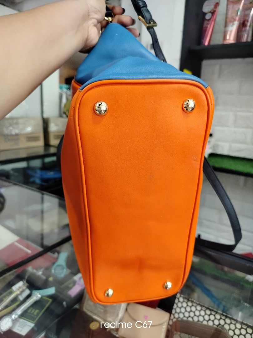 Prada Orange Blue Leather Tote Bag (Category: Luxury Bags & Wallets) located in Bacolod City. Submitted by Mike23MattPreloved (Listing ID 1452357883, Image 3). Description: - Color: Orange and Blue leather - Trim: Black leather handles and strap - Hardware: Gold details - Closure: Zipper - Condition: Minor scuffs on orange leather - Style: Great everyday bag.