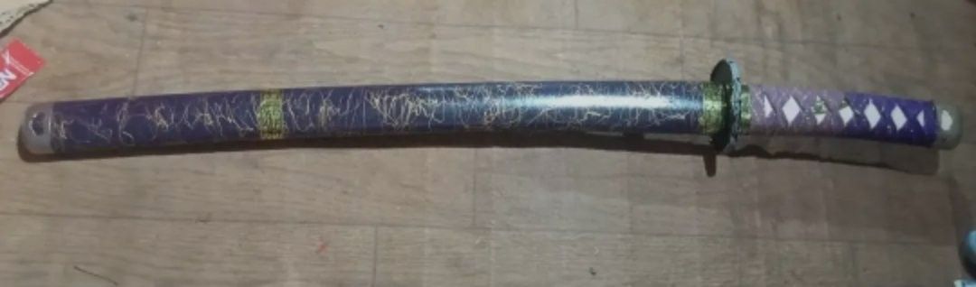Purple Decorative Sword with Ornate Handle (Category: Vintage Collectibles) located in Manila. Submitted by kyliejelly22328 (Listing ID 1452507503, Image 1). Description: Japanese vintage samurai or katana Real blade pero nd na matalim kya diaplay nlng bawal sa bata.. Decorative sword perfect for display or costumes. - Features a striking purple scabbard with a marbled pattern and elegant gold accents. - Handle is wrapped in a purple and white di