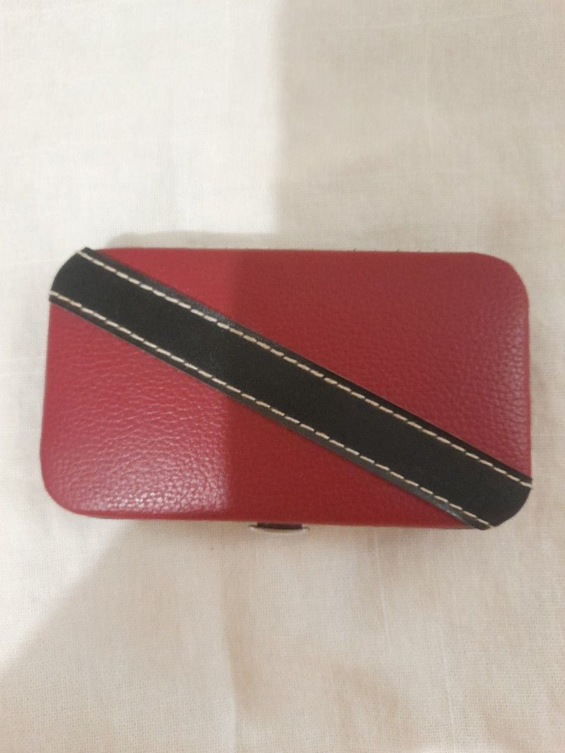 Red Leather Manicure Set (Category: Hands & Nails) located in Las Pinas. Submitted by redwine1798 (Listing ID 1452481132, Image 2). Description: - Compact manicure set in a stylish red faux leather case. - Includes essential stainless steel tools: nail clippers, scissors, tweezers, cuticle pusher, and nail file. - Features a chic diagonal black stripe with white stitching on the case. - Secure snap closure keeps everything in place. - Ideal for t
