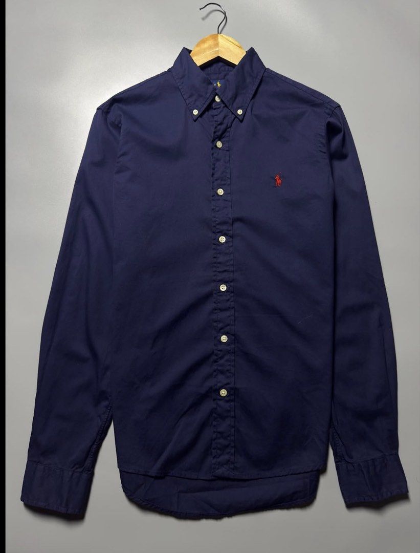 Rl navy button down red pony (Category: Luxury Apparel) located in Bacoor. Submitted by bootsknocker (Listing ID 1452478342, Image 1). Description: RALPH LAUREN Button down L/S -perfect for casual fits Fits S-M 17” width 27 “length Pristine condition 10/10 color rate AUTHENTIC✅.