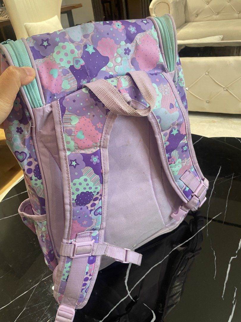 Smiggle Purple Cloud Pattern Backpack (Category: Backpacks) located in Kuala Lumpur. Submitted by chuaali97 (Listing ID 1452421021, Image 3). Description: - Adorable Smiggle backpack with a fun purple cloud and star pattern. - Main compartment for essentials. - Convenient front pocket for quick access. - Side pockets for water bottles or extra storage. - Cute heart-shaped zipper pulls. - Padded shoulder straps for maximum comfort. - Ideal for sch
