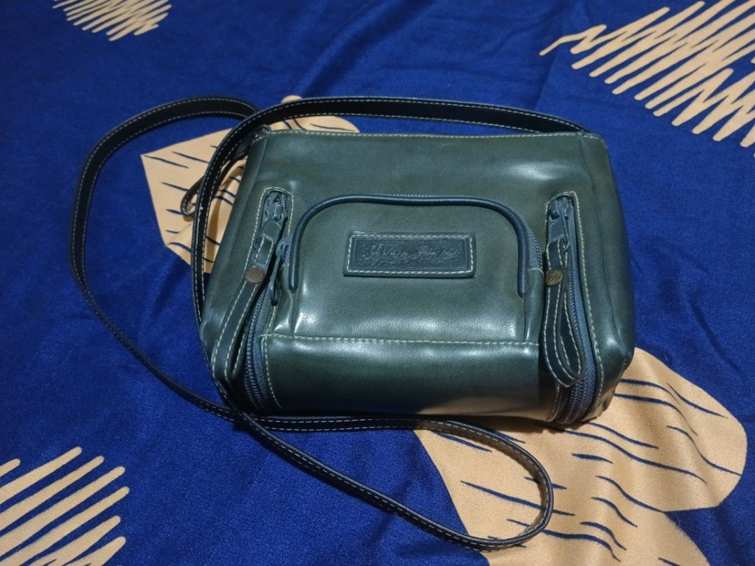 Sylvia Santos 25years old Vintage (Category: Luxury Bags & Wallets) located in Las Pinas. Submitted by juliesan123 (Listing ID 1452435833, Image 1). Description: This Sylvia Santos bag features a metallic finish and a signature leather patch. *Pre-loved or slightly used item. *The material appears to be a synthetic, metallic - coated leather. * The bag includes a zipper front pocket..