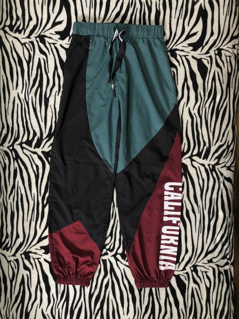 Athletic Jogger Pants (Category: Activewear) located in Muntinlupa City. Submitted by ksclocollection (Listing ID 1452672240, Image 2). Description: Cool colorblock pants (burgundy, black, teal) with elastic waistband and drawstring. Features "TONG TOU" text and white detail on burgundy leg. Perfect for sports or casual wear..