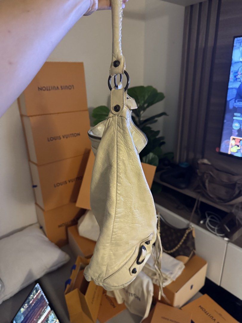 Balenciaga Hobo Shoulder Bag (Category: Shoulder Bags) located in Taguig. Submitted by byebyebabies (Listing ID 1452621759, Image 2). Description: - Cream colored leather hobo bag - Features a stylish braided strap detail - Secure zipper closure at the top - Ample space inside for your essentials - Shows some signs of wear on the leather, adding character - An excellent and versatile everyday bag.