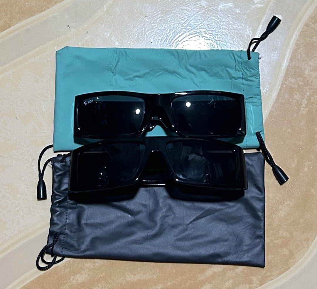 Black Sunglasses with Pouches (Category: Sunglasses & Eyewear) located in Manila. Submitted by dcoolest (Listing ID 1452652621, Image 1). Description: - Two pairs of stylish black sunglasses. - One pair has a unique bell-shaped logo. - The second pair features a 'LUCAS' logo. - Both sunglasses come with protective drawstring pouches. - One pouch is a vibrant teal color. -take all -2 pcs - The other pouch is classic black. - Ideal for protecting y