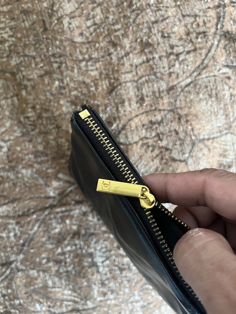 Chanel Black Patent Leather Pouch (Category: Luxury Bags & Wallets) located in Nabua. Submitted by lastthrift2.0 (Listing ID 1452602428, Image 3). Description: - Black patent leather pouch - Iconic gold CC logo - Secure zipper closure - Convenient small wrist strap - Ideal for carrying essentials - Versatile as a clutch or bag organizer.