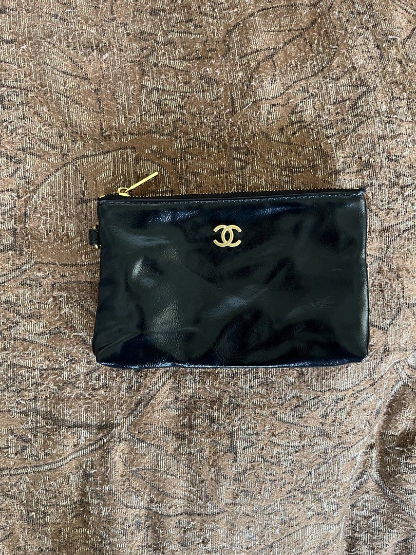 Chanel Black Patent Leather Pouch (Category: Luxury Bags & Wallets) located in Nabua. Submitted by lastthrift2.0 (Listing ID 1452602428, Image 1). Description: - Black patent leather pouch - Iconic gold CC logo - Secure zipper closure - Convenient small wrist strap - Ideal for carrying essentials - Versatile as a clutch or bag organizer.