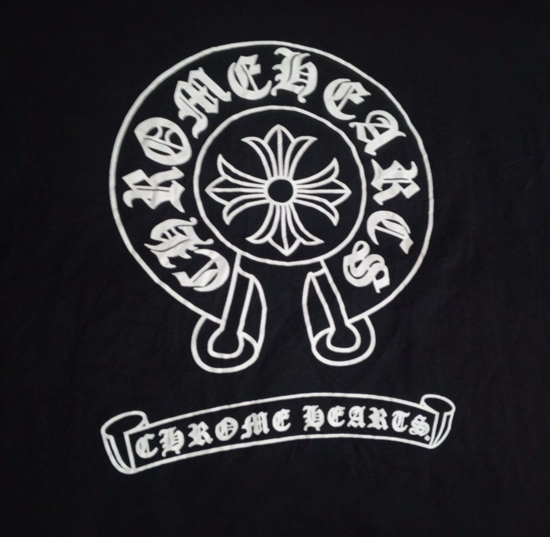 Chrome Hearts Black T-Shirt with Logo (Category: Tshirts & Polo Shirts ) located in Manila. Submitted by kents_thrift (Listing ID 1452687859, Image 2). Description: - Dimes: 20x25 - Cut Tags - Clasic black t-shirt - Features the iconic Chrome Hearts logo on the front - Circular logo with brand name and banner text - Simple and timeless design - Ideal for casual wear.