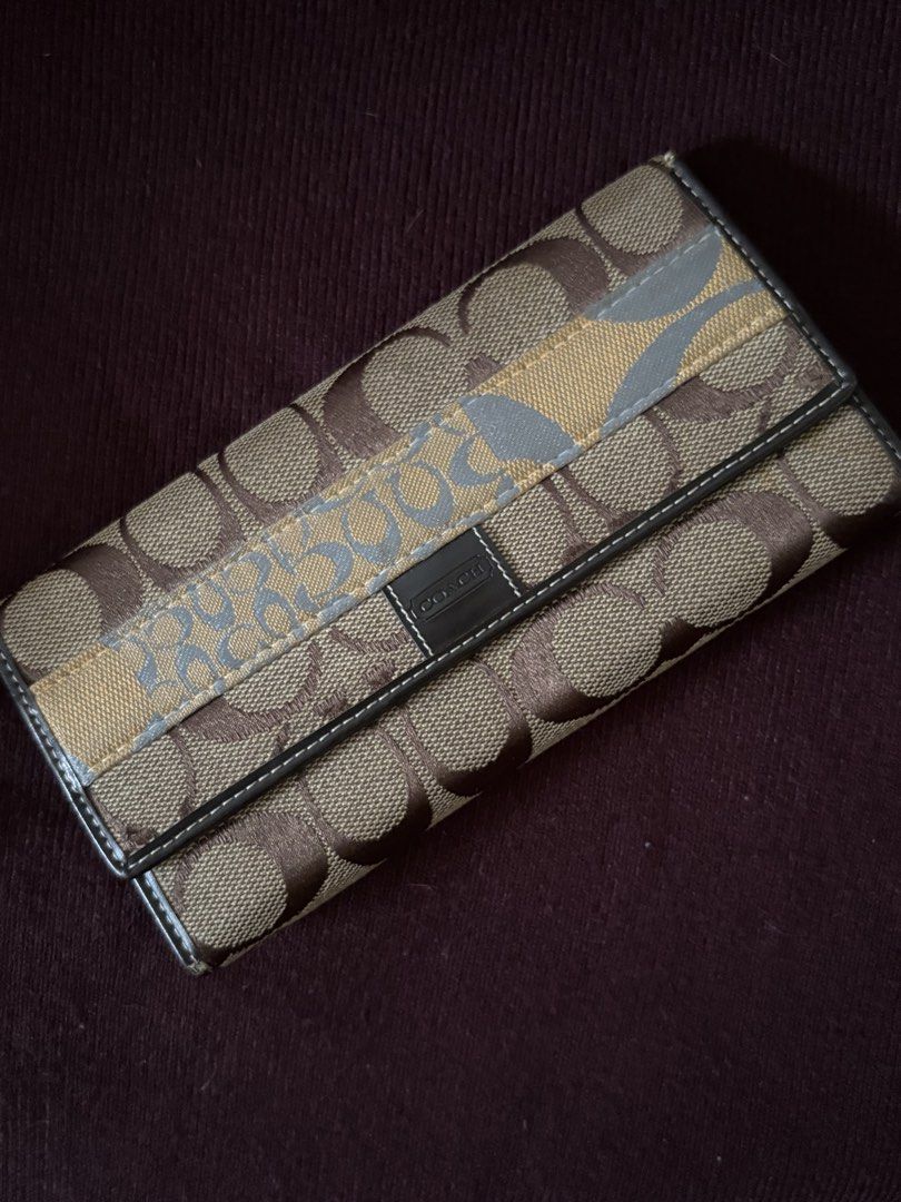 Coach Signature Canvas Trifold Wallet (Category: Luxury Bags & Wallets) located in Manila. Submitted by librastudio (Listing ID 1452564996, Image 1). Description: - Authentic Coach trifold wallet - Signature canvas in brown and tan with grey stripe detail - Ample card slots for organization - Secure snap closure - Note: Minor wear on interior pocket edges.