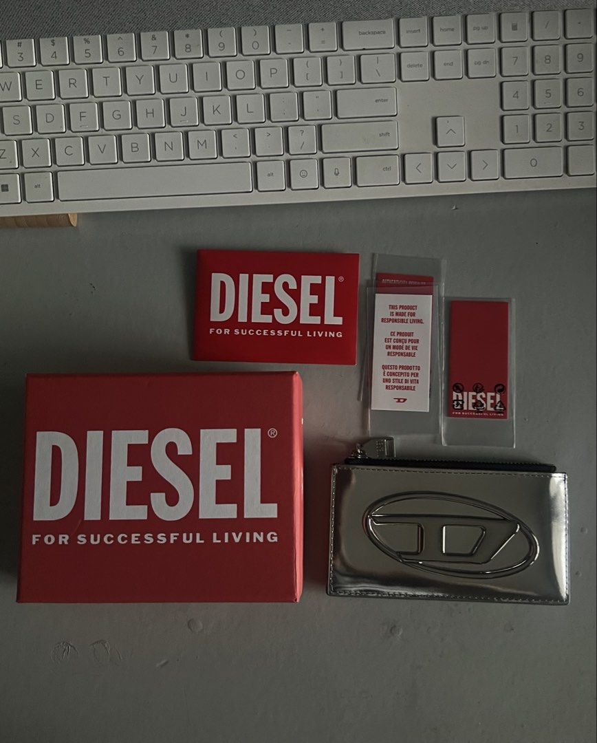 Diesel Card Holder In Mirror Leather Silver (Category: Wallets & Card holders) located in Makati City. Submitted by heybyemystuff (Listing ID 1452570110, Image 1). Description: - Brand: Diesel - Material: Silver mirror leather - Closure: Zipper - Includes: Original box and tags - Features: Keeps cards organized, sleek and stylish design Bought in Japan.