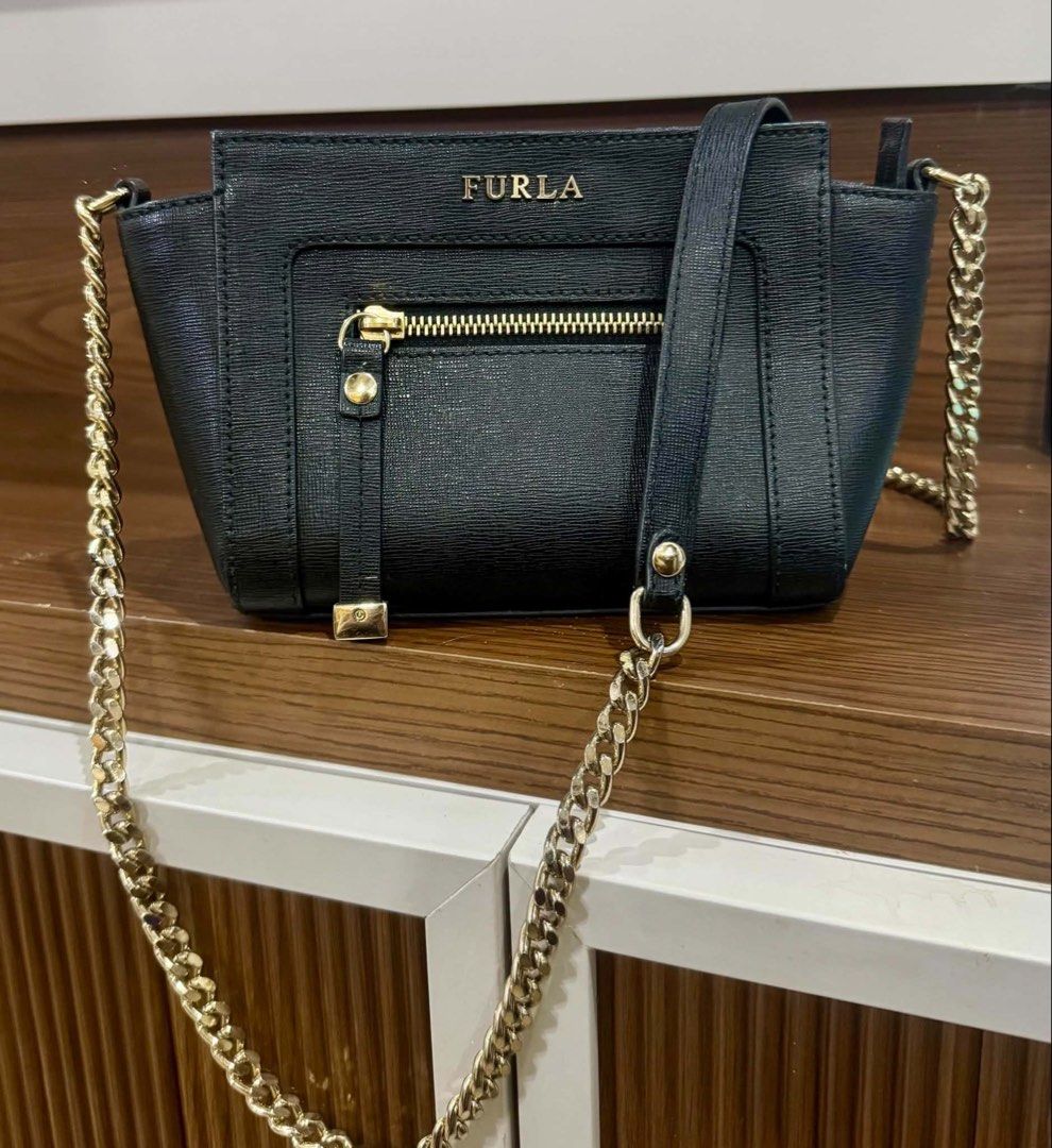 Furla Black Leather Crossbody Bag (Category: Cross-body Bags) located in Manila. Submitted by westbridge007 (Listing ID 1452613264, Image 1). Description: Authentic Furla Black Leather Crossbody Bag • Genuine leather • Elegant black color with gold-tone hardware • Zip front pocket • Adjustable shoulder strap with chain detail • Good pre-owned condition • Normal signs of use only • Comes with: Bag only Perfect for daily use, work, or casual outing