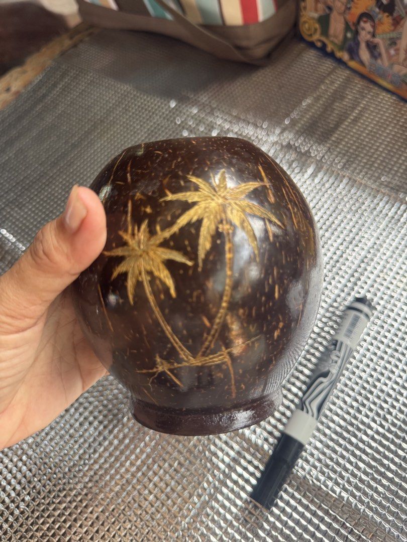 Hand-carved Coconut Shell Cup with Palm Tree Design (Category: Dinnerware & Cutlery) located in Santa Cruz. Submitted by maqui15 (Listing ID 1452509451, Image 2). Description: - Unique cup crafted from a real coconut shell. - Features a hand-carved palm tree design. - Smooth, polished finish for a premium feel. - Versatile: Use for drinks or as a decorative piece. - Size: Approximately 4 inches tall. - Adds a perfect tropical vibe to any setting.