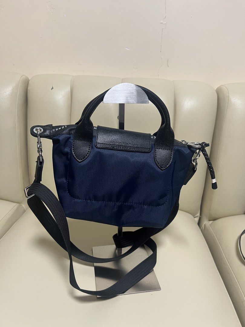 Longchamp Le Pliage Energy Mini Navy (Category: Luxury Bags & Wallets) located in Manila. Submitted by gailmg (Listing ID 1452587891, Image 2). Description: - Authentic! - Navy blue Longchamp mini bag - Top handles and detachable shoulder strap - Black leather trim - Flap closure with snap button - Top zippers - Small size, ideal for essentials - Great for casual outings or light travel.