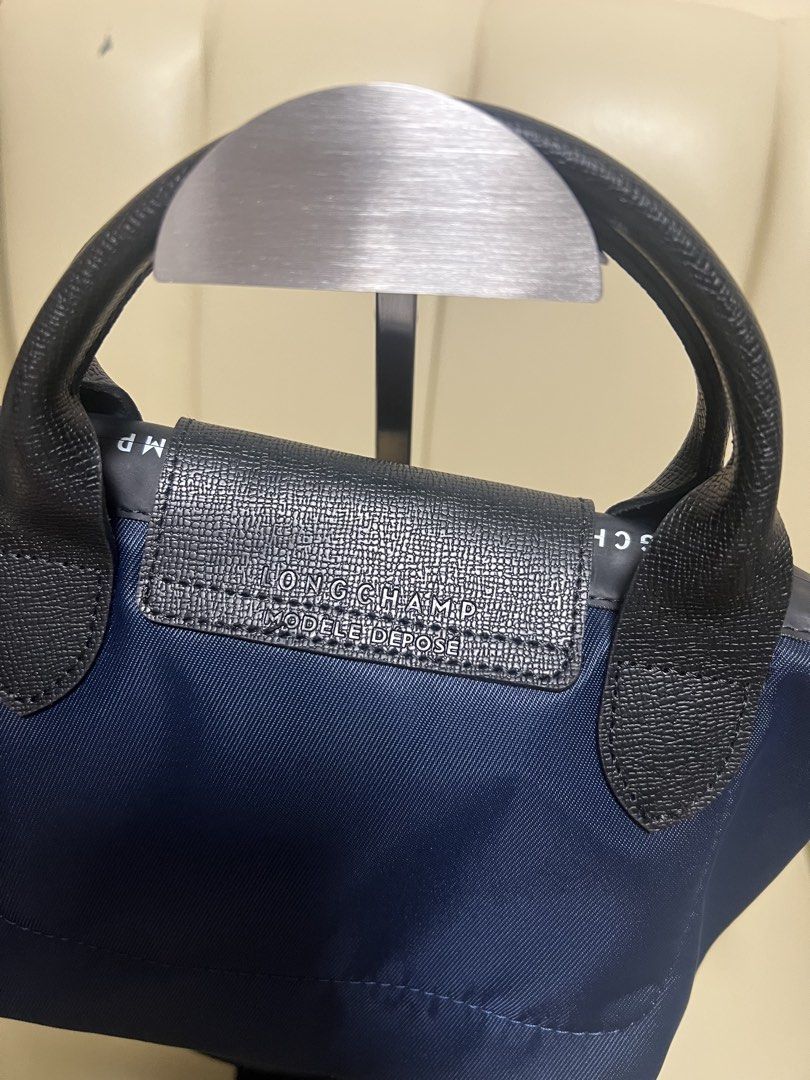 Longchamp Le Pliage Energy Mini Navy (Category: Luxury Bags & Wallets) located in Manila. Submitted by gailmg (Listing ID 1452587891, Image 3). Description: - Authentic! - Navy blue Longchamp mini bag - Top handles and detachable shoulder strap - Black leather trim - Flap closure with snap button - Top zippers - Small size, ideal for essentials - Great for casual outings or light travel.