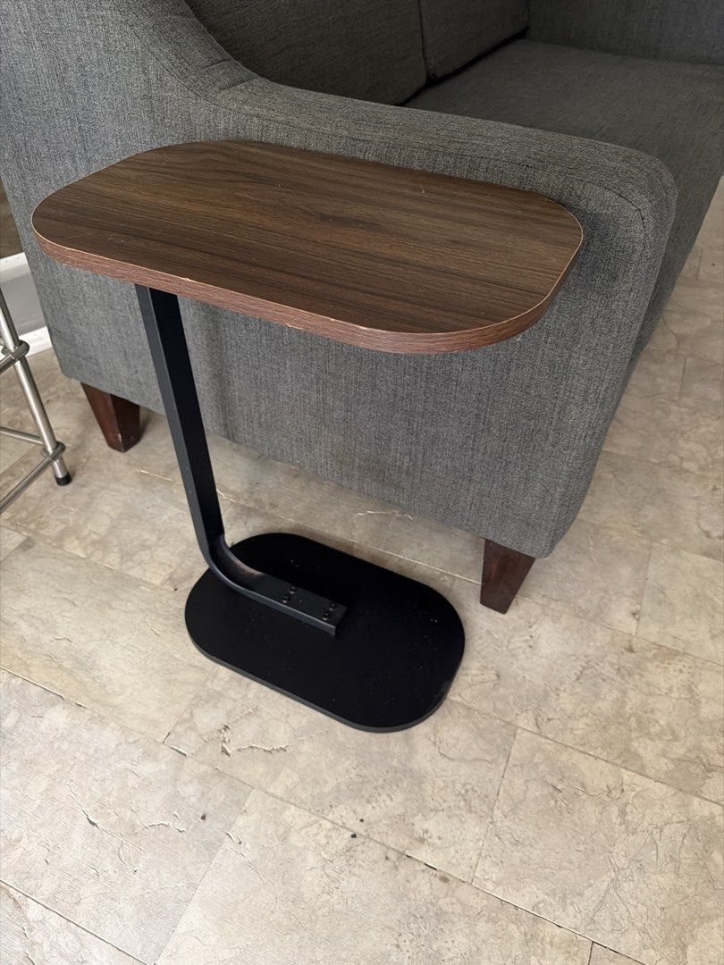 Modern Walnut Top Side Table with Black Metal Base (Category: Tables & Sets) located in Manila. Submitted by uys958 (Listing ID 1452510262, Image 2). Description: - Walnut-look top for a modern aesthetic - Sturdy black metal base with a sleek, curved design - Slides easily under chairs and sofas for space-saving convenience - Perfect for holding drinks, books, remotes, or a small lamp - Versatile use in living rooms, bedrooms, or any cozy corner 