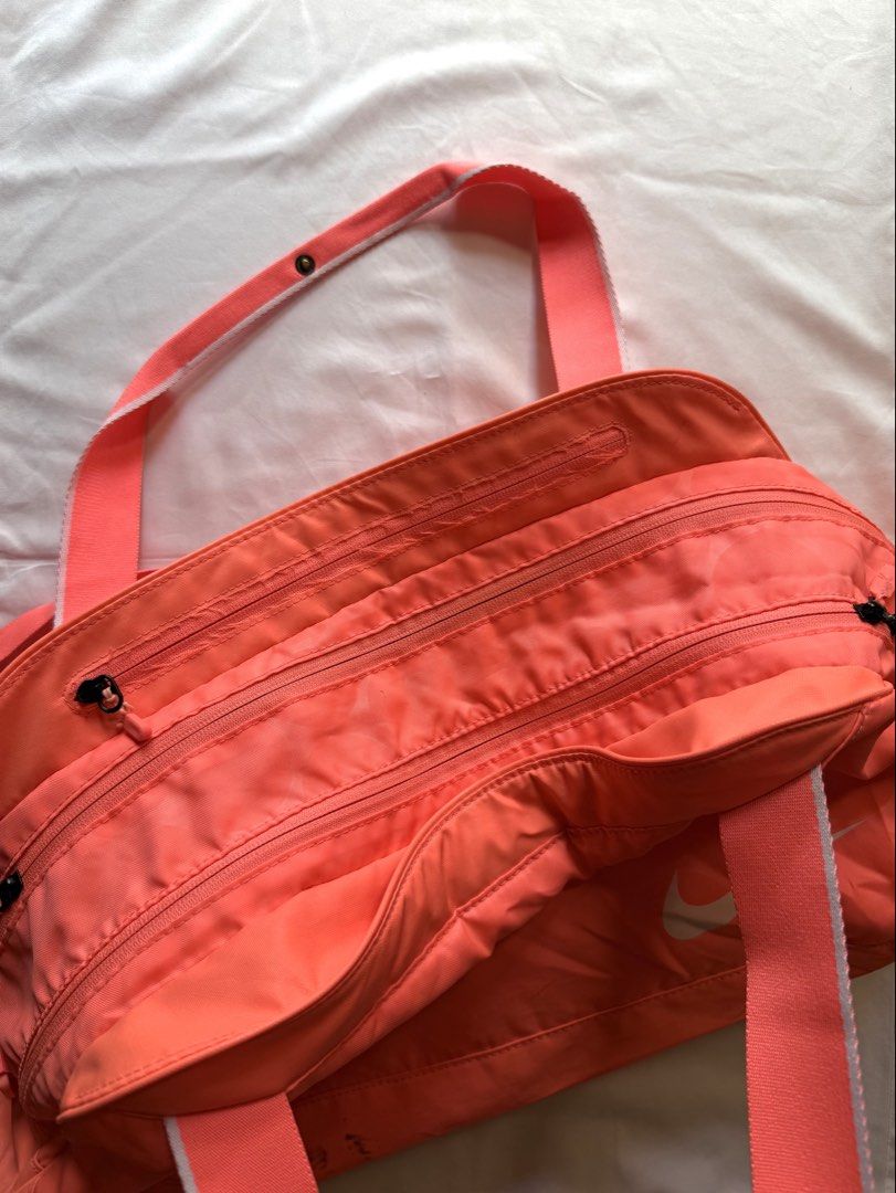 Nike Coral Pink Duffel Bag (Category: Cross-body Bags) located in Quezon City. Submitted by janavdd (Listing ID 1452578695, Image 2). Description: Selling a Nike Coral Pink Duffel Bag! - All-over patterned design - Two main zippered compartments - Two handles and a detachable shoulder strap - Ideal for gym sessions or short trips - Minor marks on the bottom (please check photos for details) MOP: GCash, BDO, BPI Shipping Method: GOGO Express, Grab