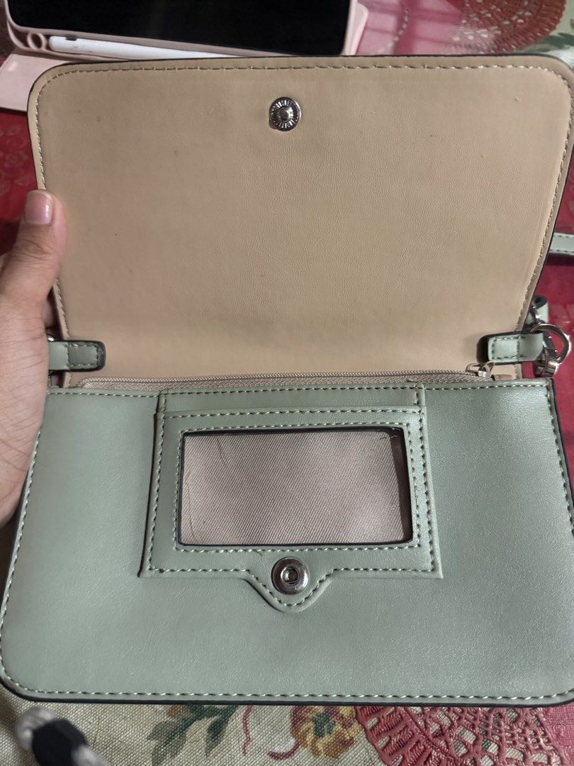 Nine West Wallet Clutch with Strap (Category: Luxury Bags & Wallets) located in San Fernando. Submitted by japanvintageaccessories (Listing ID 1452613958, Image 2). Description: - Brand: Nine West - Color: Beige and Light Green - Style: Wallet Clutch - Exterior: Patterned - Closure: Snap - Interior: Card slots, zippered compartment - Features: Clear ID window on front flap - Additional: Detachable strap included.