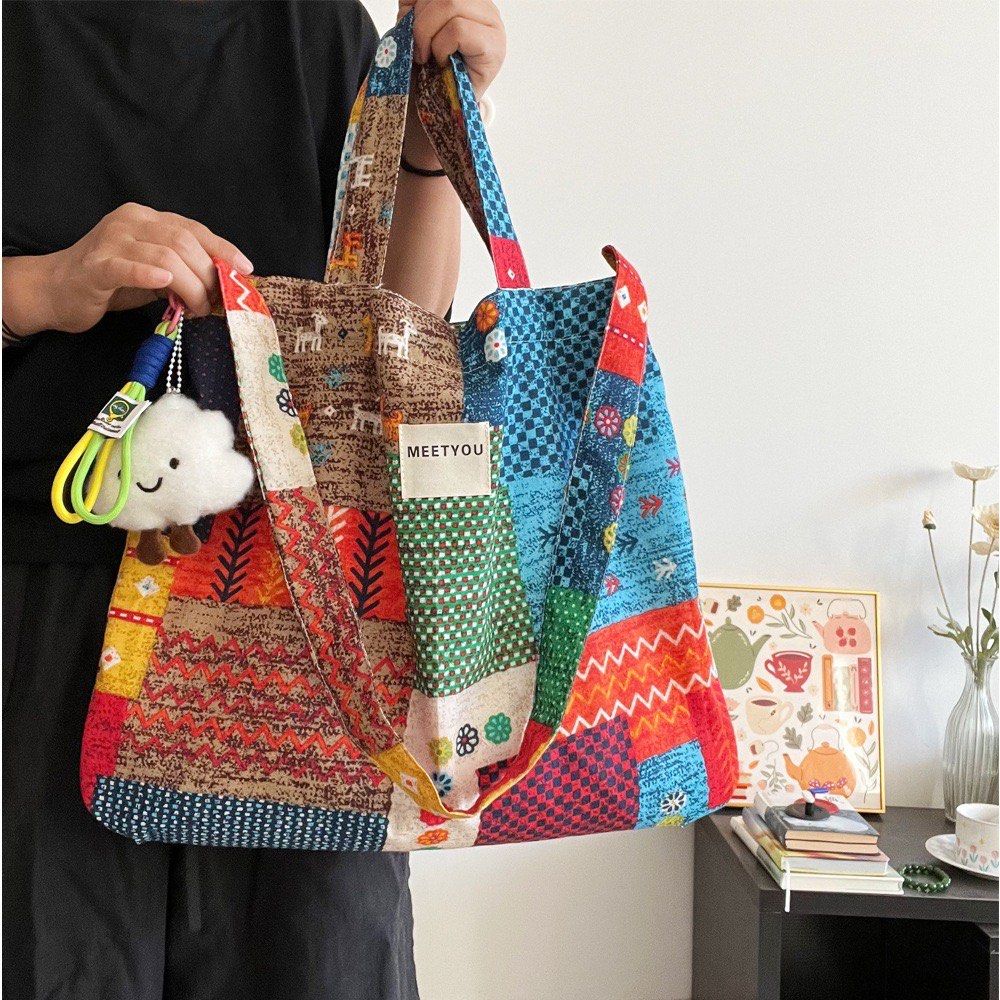 Patchwork Tote Bag (Category: Tote Bags) located in Singapore. Submitted by fiveftfour (Listing ID 1452576644, Image 2). Description: - Super cute patchwork tote bag - Features colorful patterns all over - Comes with a fun cloud charm - Ideal for everyday use or travel - Spacious interior - Comfortable straps for carrying - Unique and eye-catching design.