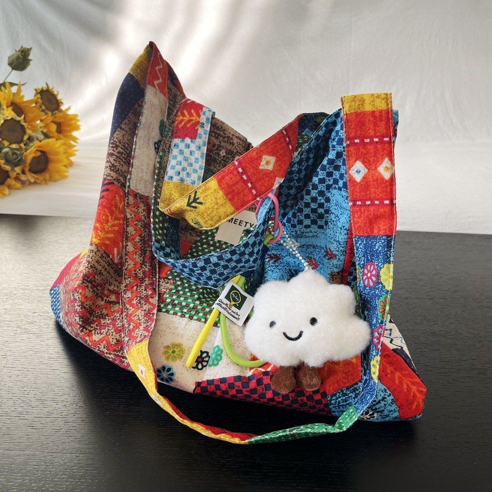 Patchwork Tote Bag (Category: Tote Bags) located in Singapore. Submitted by fiveftfour (Listing ID 1452576644, Image 3). Description: - Super cute patchwork tote bag - Features colorful patterns all over - Comes with a fun cloud charm - Ideal for everyday use or travel - Spacious interior - Comfortable straps for carrying - Unique and eye-catching design.