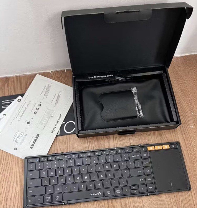 ProtoArc XK01 Foldable Bluetooth Keyboard with Trackpad (Category: Computer Keyboard) located in Cavite. Submitted by baobaodeclutter (Listing ID 1452581810, Image 2). Description: - ProtoArc XK01 Foldable Bluetooth Keyboard (Black Grey) - Built-in Trackpad for easy navigation - Integrated Phone Stand for hands-free use - Rechargeable battery for convenience - Includes protective sleeve for portability - Wireless connectivity via Bluetooth - Idea