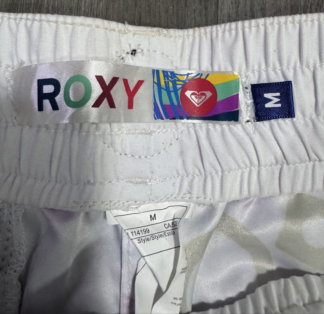 Roxy White Multi-Color Logo Print Board Shorts Size M (Category: Shorts) located in Las Pinas. Submitted by vanethneth (Listing ID 1452640628, Image 3). Description: - Roxy Board Shorts - Size: Medium (M) - Color: White with all-over logo print - Print Colors: Pink, purple, black, grey - Features: Drawstring waist, back zippered pocket, elastic waistband for comfort - Ideal for: Beach days, casual outings.
