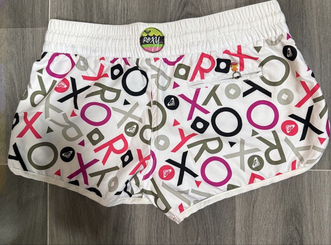 Roxy White Multi-Color Logo Print Board Shorts Size M (Category: Shorts) located in Las Pinas. Submitted by vanethneth (Listing ID 1452640628, Image 2). Description: - Roxy Board Shorts - Size: Medium (M) - Color: White with all-over logo print - Print Colors: Pink, purple, black, grey - Features: Drawstring waist, back zippered pocket, elastic waistband for comfort - Ideal for: Beach days, casual outings.