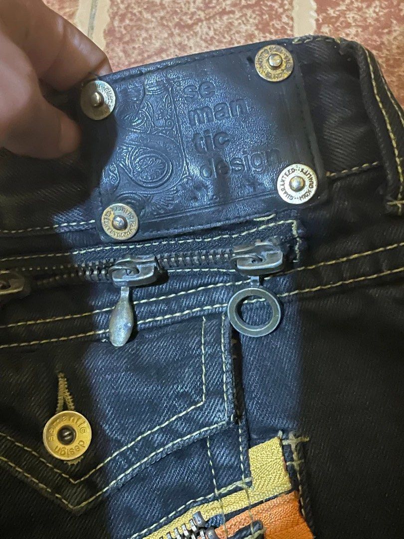Semantic Design Multi Zip Leather Patch Flared Jeans🇯🇵 (Category: Jeans) located in Caloocan City. Submitted by nagumo.fuku_ (Listing ID 1452560532, Image 3). Description: - Brand: SEMANTIC DESIGN - Color: Black Denim - Fit: Relaxed with a slight flare at the bottom - Pockets: Multiple zip pockets (front and back) - Unique Details: Orange and yellow accents on back pockets - Style: Casual, edgy.