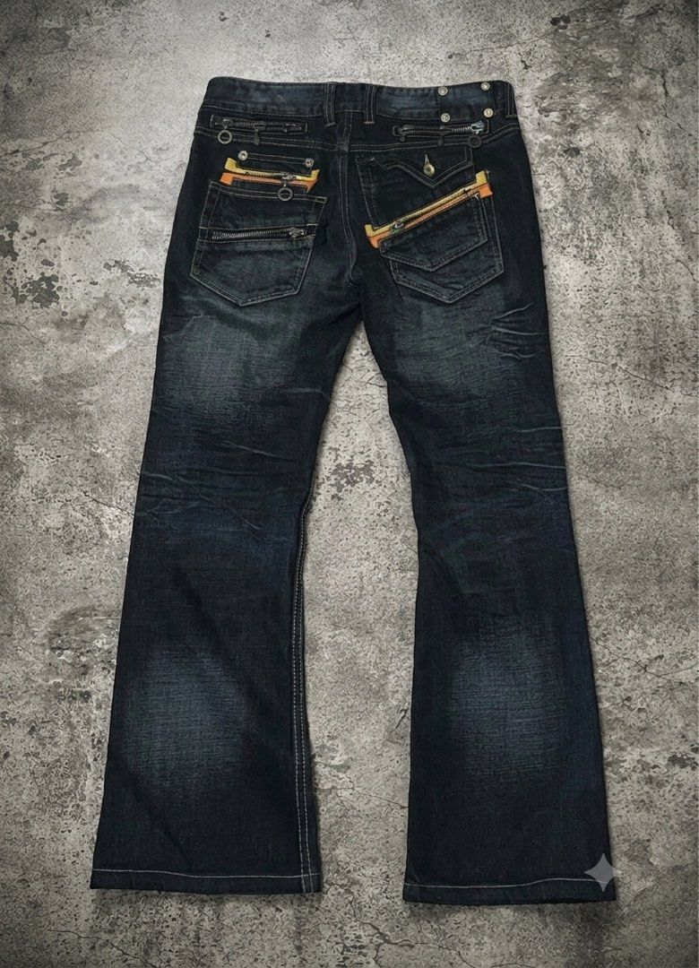Semantic Design Multi Zip Leather Patch Flared Jeans🇯🇵 (Category: Jeans) located in Caloocan City. Submitted by nagumo.fuku_ (Listing ID 1452560532, Image 2). Description: - Brand: SEMANTIC DESIGN - Color: Black Denim - Fit: Relaxed with a slight flare at the bottom - Pockets: Multiple zip pockets (front and back) - Unique Details: Orange and yellow accents on back pockets - Style: Casual, edgy.