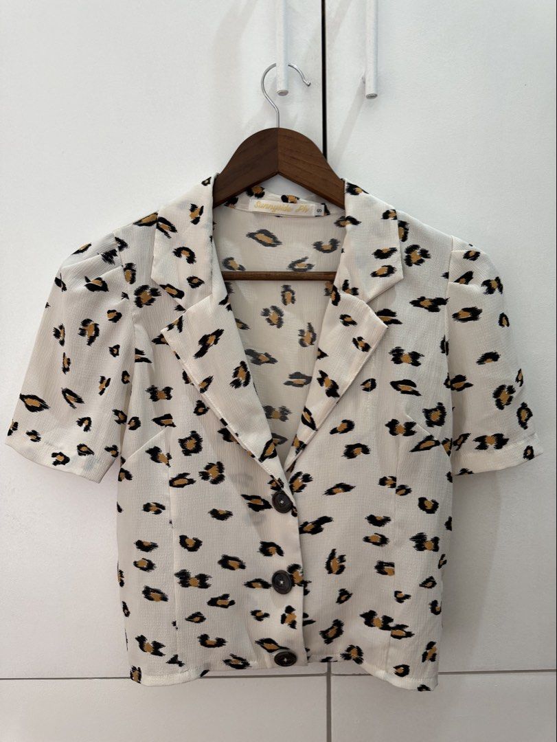 Sunnyside Fly Leopard Print Short Sleeve Blazer Top (Category: Blouses) located in Antipolo. Submitted by errrilemon (Listing ID 1452550185, Image 1). Description: - Classic leopard print short sleeve top - Features a collared neckline and button-up front - Stylish puff sleeves for added detail - Versatile: pairs well with jeans or skirts - Ideal for casual outings or nights with friends.