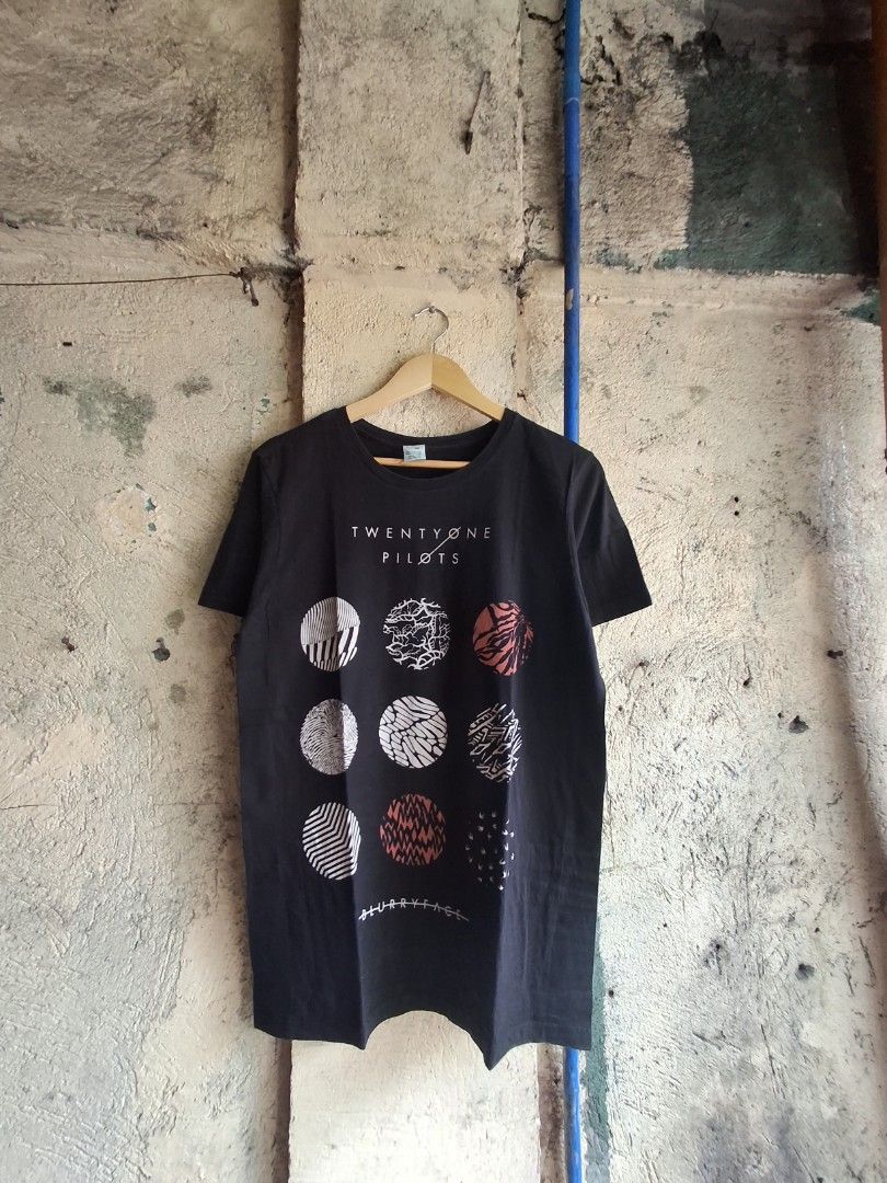 Twenty One Pilots Blurryface T-Shirt (Category: Activewear) located in Quezon City. Submitted by Thriftallthetime (Listing ID 1452576618, Image 1). Description: - Black t-shirt featuring iconic Blurryface album art. - Includes the Twenty One Pilots logo on the side. - Made from 100% comfortable cotton. - A must-have for any fan of the band. - Showcases the album's distinctive circular designs. - Own a piece of music memorabilia..