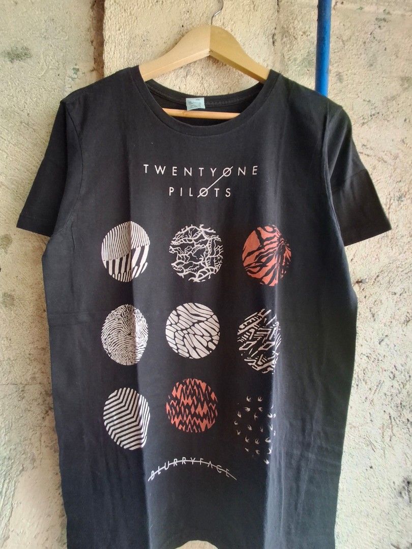 Twenty One Pilots Blurryface T-Shirt (Category: Activewear) located in Quezon City. Submitted by Thriftallthetime (Listing ID 1452576618, Image 2). Description: - Black t-shirt featuring iconic Blurryface album art. - Includes the Twenty One Pilots logo on the side. - Made from 100% comfortable cotton. - A must-have for any fan of the band. - Showcases the album's distinctive circular designs. - Own a piece of music memorabilia..